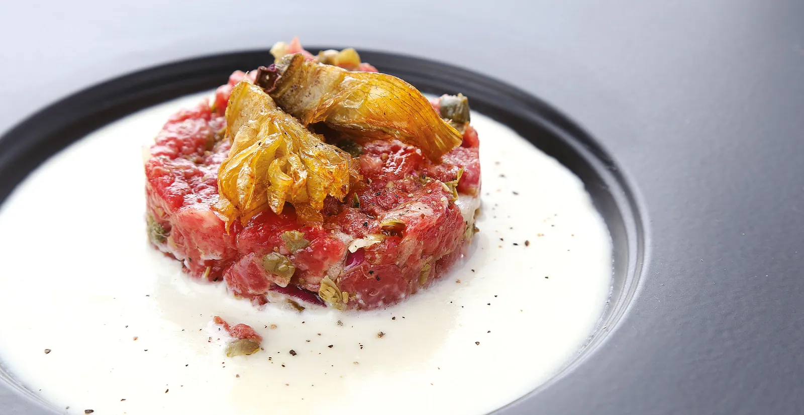 Tartare di carne scozzese con fonduta al parmigiano e corona di carciofini croccante