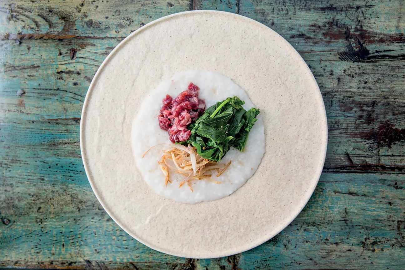 Congee di riso jasmine, crudo di pecora, cime di rapa acidulate, scalogni fritti