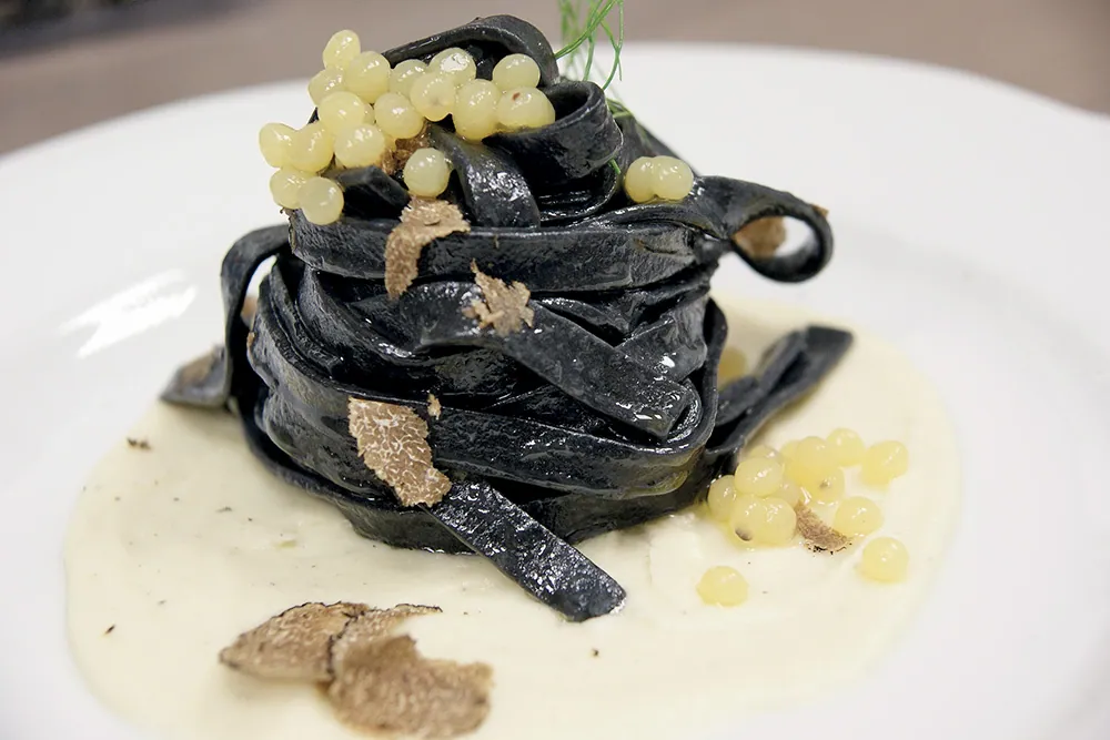 Tagliatelle al nero su crema di topinambur, caviale di kiwi e scaglie di tartufo