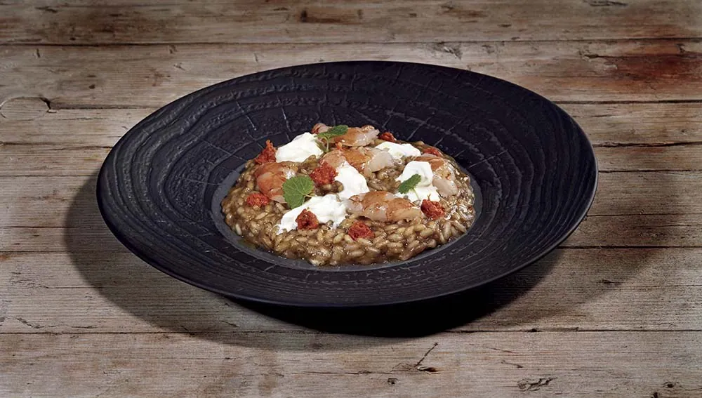Risotto mantecato con crema di melanzane leggermente affumicata, battuto di gamberi, stracciatella di burrata e pesto rosso alla siciliana