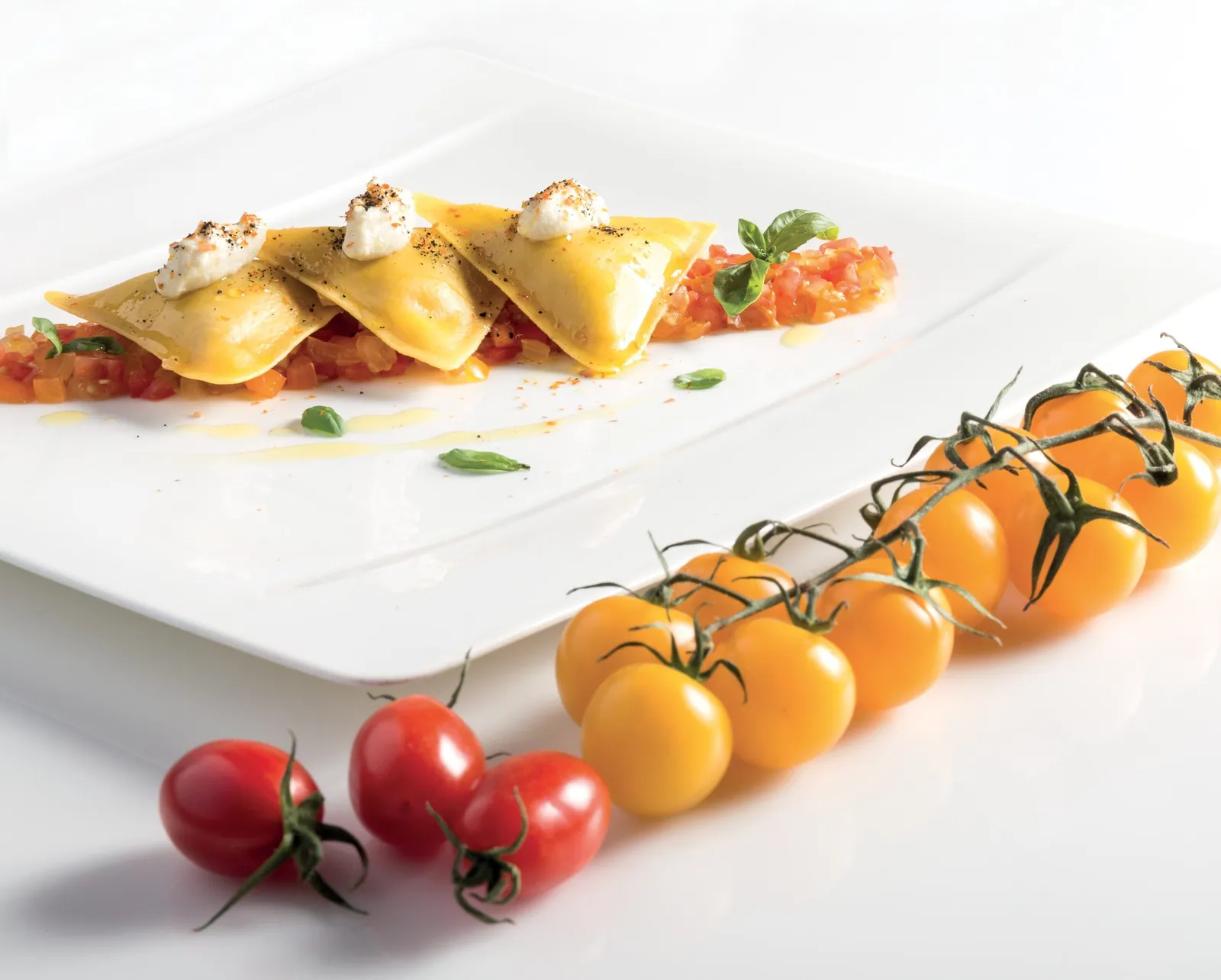 Triangoli al pesce spada con crudaiola di ciliegino Pachino, datterino arancione e ciliegino lemon, spuma di olive e pomodoro secco